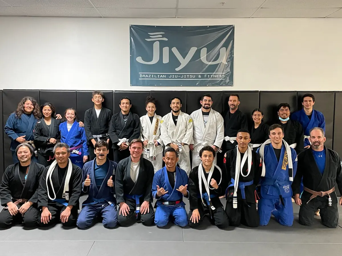 Jiyu students and coaches lined up on the mats under the Jiyu banner